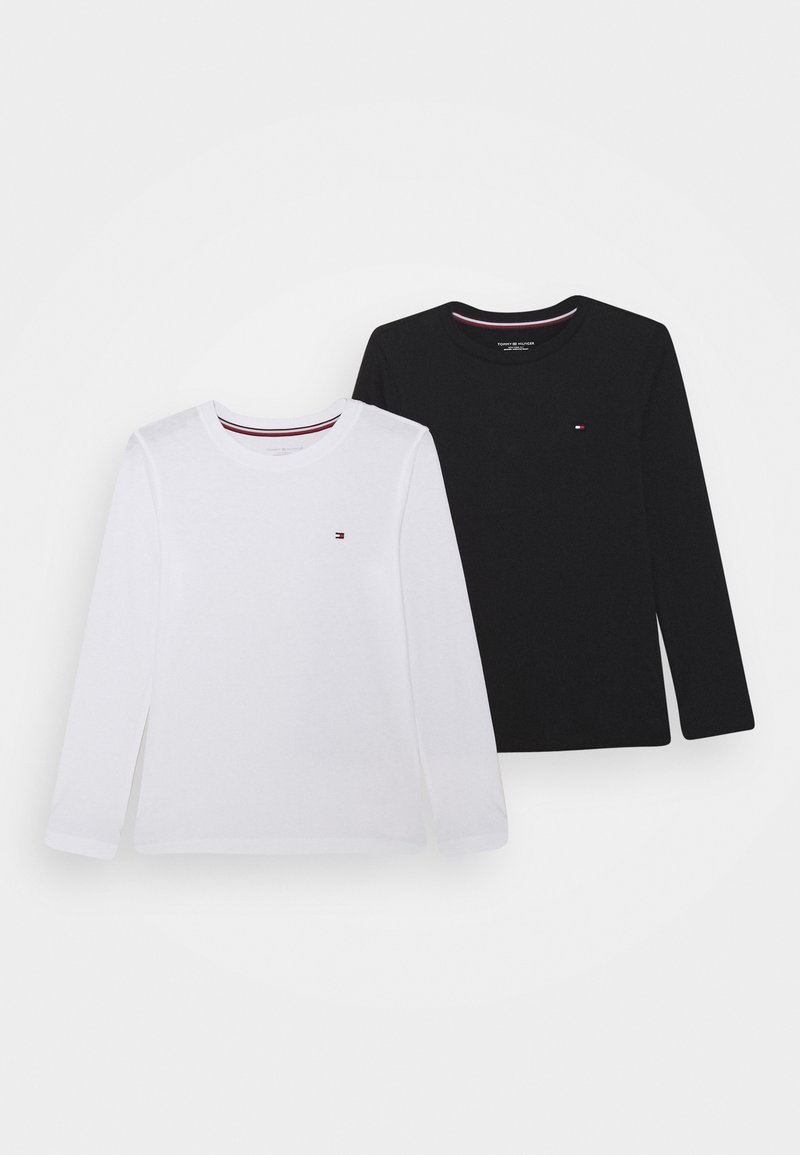 Langarm-T-Shirts aus Baumwolle in Weiß und Schwarz. Jedes Shirt hat ein kleines Logo auf der Brust und einen kontrastierenden Halsausschnitt mit roten und weißen Streifen.