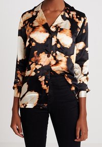 Svart och guld satin skjorta med ett blommigt mönster, med en krage, långa ärmar, knäppt framtill och uppvikta manschetter.