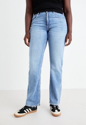 Light blue denim jeans with a straight-leg design, mid-rise waist, subtle stitching, and worn appearance, paired with black and white sneakers.