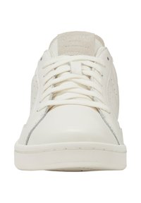 Zapatillas de cuero blancas con lengüeta de ante, cordones planos, diseño perforado y suela de goma texturizada. Sutiles acentos grises en el lateral.