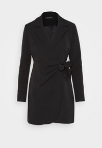 Blazer negro ajustado con mangas largas, cuello con solapa y un detalle de lazo en el frente. Confeccionado en una tela suave con un diseño elegante y estructurado.
