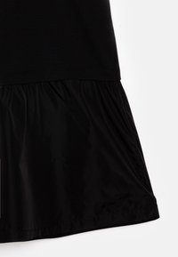 Must mustrind, millekordne särg ja helde seelik kerge läikiva tekstuuriga. Õmblusdetailid ääres.