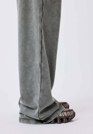 Grijze sweatpants met een zachte textuur en een tapered ontwerp, gecombineerd met bruine sportschoenen met een onderscheidend loopvlak.