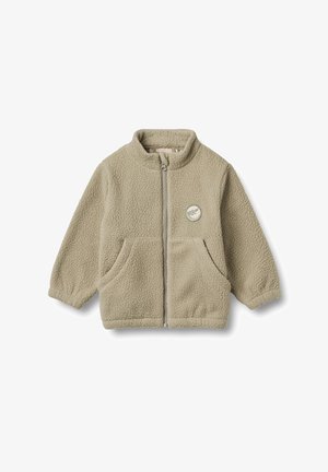 Giacca in pile di un beige chiaro con colletto alto, zip frontale, due tasche laterali e un dettaglio a toppa circolare sul lato sinistro del petto.