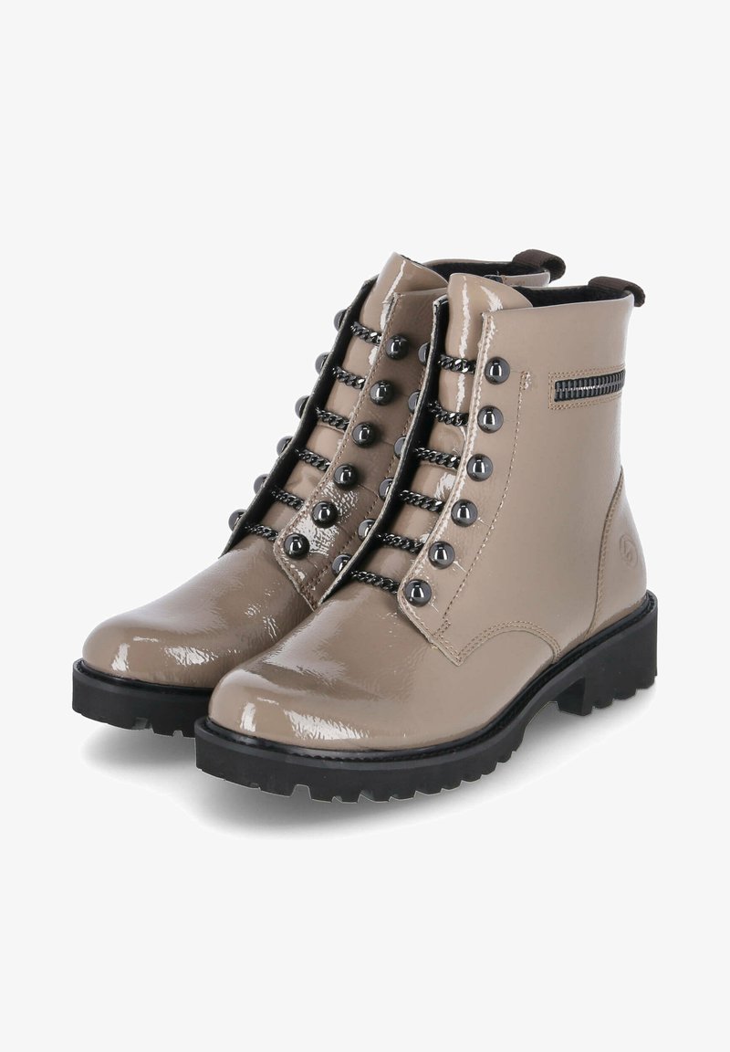 Botines de charol beige con punta redonda, herrajes negros, cordones en contraste y detalle de cremallera lateral. Suela de goma negra gruesa.