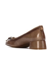 Zapatos de charol marrón de tacón bajo con punta redondeada, detalle de lazo y un pequeño acento de logo circular en la parte posterior.
