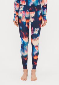 Barvite, raztegljive legice v tie-dye vzorcu z odtenki modre, oranžne in bele barve, z oprijetim dizajnom in gladko teksturo.