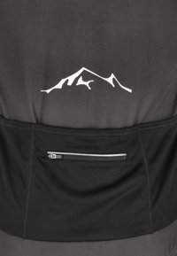 Gros plan sur l'arrière d'un vêtement de sport noir avec un logo montagne blanc au-dessus d'une poche en filet zippée.
