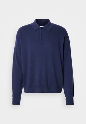 Pulover tamnoplave boje s ovratnikom, dugim rukavima i rebrastim manžetama. Mekana tekstura s opuštenim krojem i tri dugmeta na prednjem dijelu.