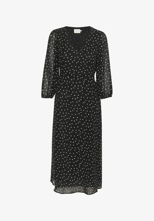 Svart klänning med V-ringning och trekvartsärmar, prydd med vita prickar, tillverkad av lätt material, med en flödande silhuett.
