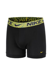 Bóxers negros con una cinturilla amarilla con un patrón que presenta el logo de Nike. Están hechos de un material elástico para mayor comodidad y ajuste.