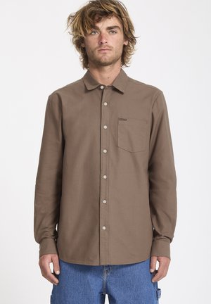 Bruine langemouwen shirt met een button-down kraag, borstzak en lichtgekleurde knopen, gemaakt van een zachte stof.