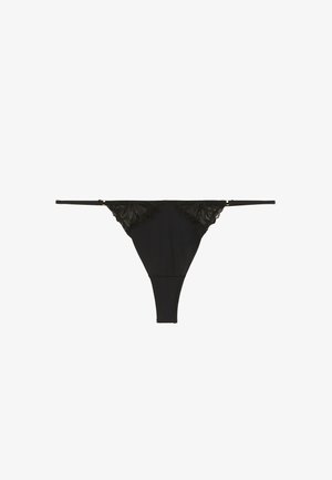 Culotte string noire avec des accents en dentelle à l'avant, tissu lisse, fines bretelles et un design offrant une couverture minimale à l'arrière.