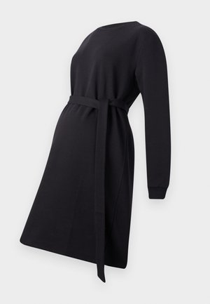 Zwarte zwangerschapsjurk gemaakt van zachte stof, met lange mouwen, een ronde halslijn en een strikceintuur op de taille voor aanpassing.