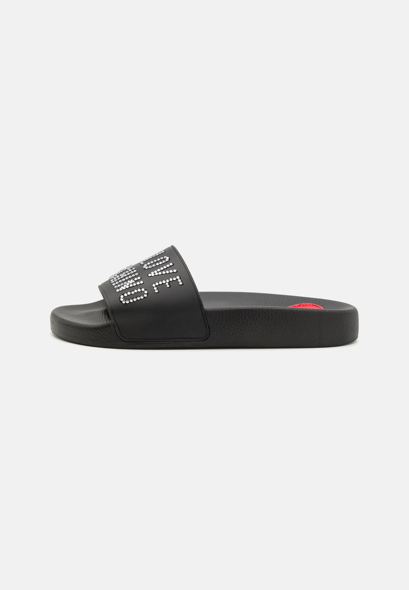 Black slide sandal with a textured surface, featuring a wide strap adorned with rhinestones spelling "LOVE." Red accent on the sole.