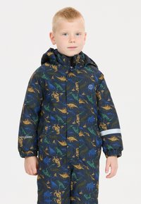 Waterdichte overall voor kinderen in donkerblauw met een kleurrijke dinosaurusprint. Voorzien van een capuchon en een reflecterende strip op de mouw.