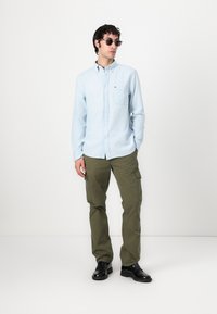 Tommy Hilfiger POCKET SHIRT UNISEX - Button-down blouse - light blue chambray