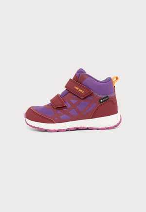 Baskets pour enfants violet et bordeaux avec deux bandes velcro, semelle blanche, bande de roulement rose et languette orange au talon.