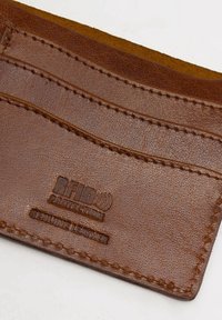 Hnedá kožená peňaženka na karty s RFID ochranou, obsahujúca viacero slotov na karty a embosovaný text. Prešívané okraje dodávajú textúru.