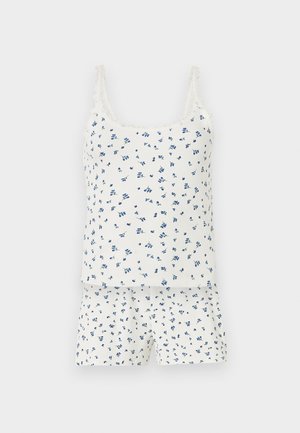 Λευκό σετ με ριμπ αμάνικα και σορτσάκια με μικρό μπλε φλοράλ σχέδιο και δαντέλα στα λουράκια του τοπ.