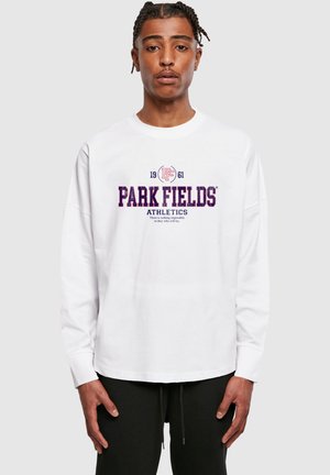 Fehér, hosszú ujjú póló, amelyen lila színű felirat található: "PARK FIELDS ATHLETICS", valamint egy logó és az alapítás éve: "1961". Egyszerű dizájn.
