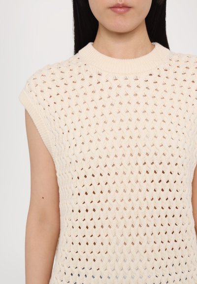 Pleteni bezrukavni top u svijetloj bež boji, s otvorenim mrežastim uzorkom, okruglim izrezom i rebrastim rubom, koji prikazuje meku teksturu.
