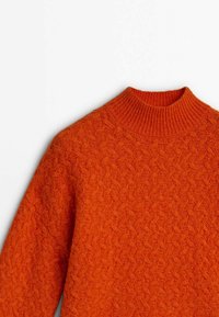 Pull en maille orange avec un col montant côtelé et un motif zigzag texturé sur fond blanc.