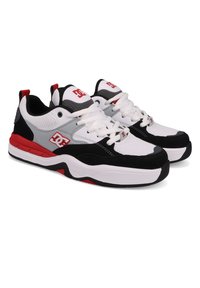 White sneakers with black and red accents, synthetic and mesh materials, round toe, rubber sole, featuring a logo on the tongue and side.