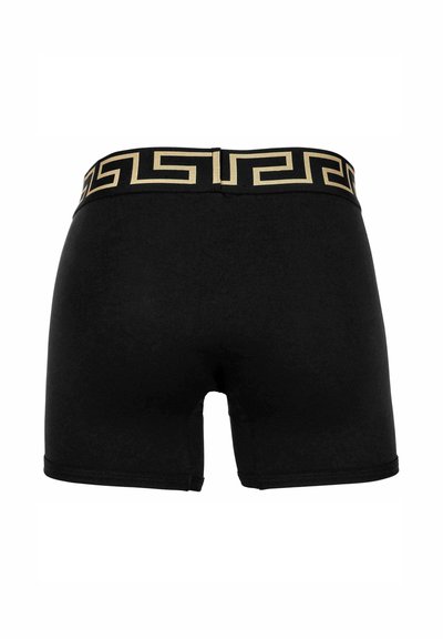 Black boxer shorts with a gold patterned waistband. Material appears elastic and fitted, showcasing a simple design without additional details.