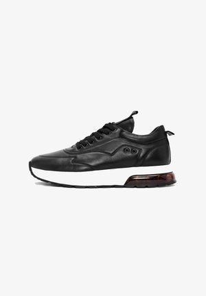 Czarny skórzany sneaker z czarnymi sznurówkami, białą podeszwą środkową i przezroczystą poduszką powietrzną w pięcie, przedstawiony z lewej strony.