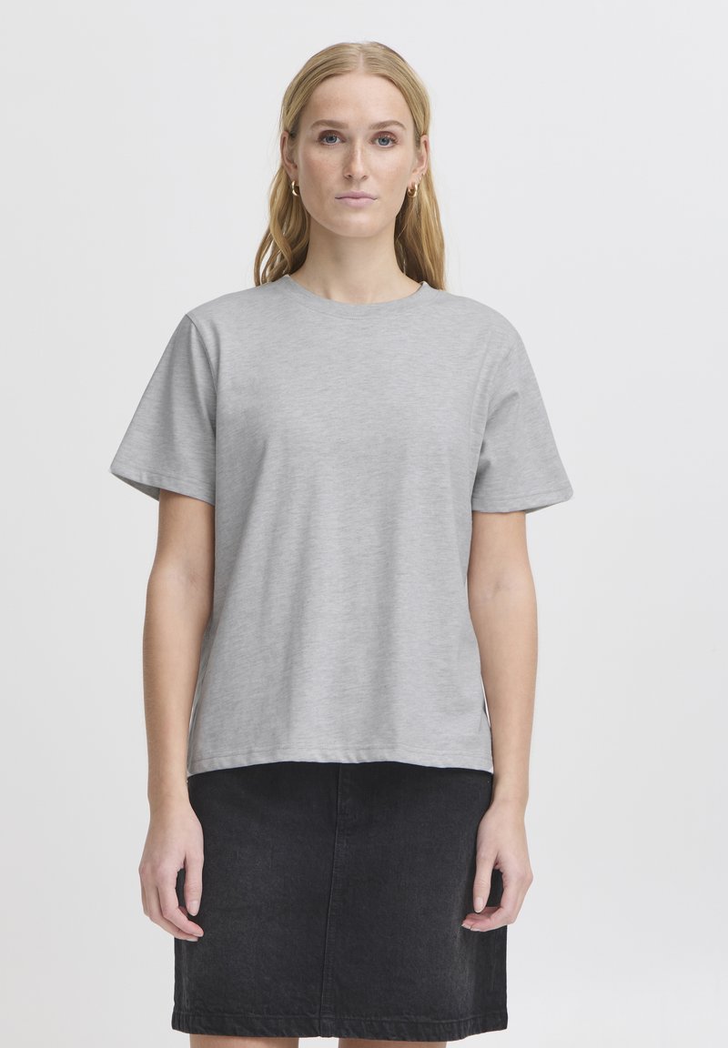 Pilkas trumpas rankovėmis marškinėliai, apvaliu kaklu, laisvas laisvasis kirpimas, minkšta tekstūra, derinami su juodais džinsiniais sijonais, minimalizmo dizainas, be raštų.