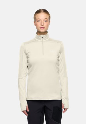 Hellbeige, langärmliges Zip-Up-Oberteil mit hohem Kragen, schmalem Schnitt und weichem Stoff. Mit dezentem Logodetail auf der Brust.