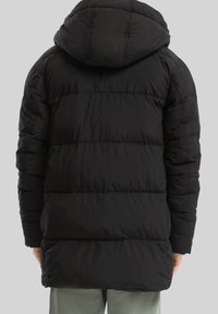 Čierny péřový kabát s kapucňou, ktorý má prešívaný dizajn, bočné vrecká a stredne dlhý strih, vyrobený z hladkej, lesklej tkaniny.