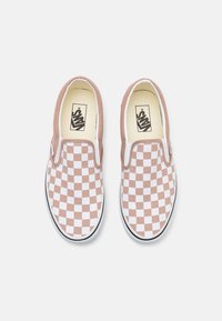 Zapatillas sin cordones con un patrón de cuadros en rosa y blanco. Material de lona, cuello acolchado, suela de goma negra y logo de Vans en el interior.