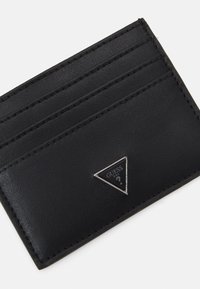 Portafoglio in pelle nera a trama con tre scomparti per carte e un logo triangolare argentato sul fronte. Design compatto, forma elegante.