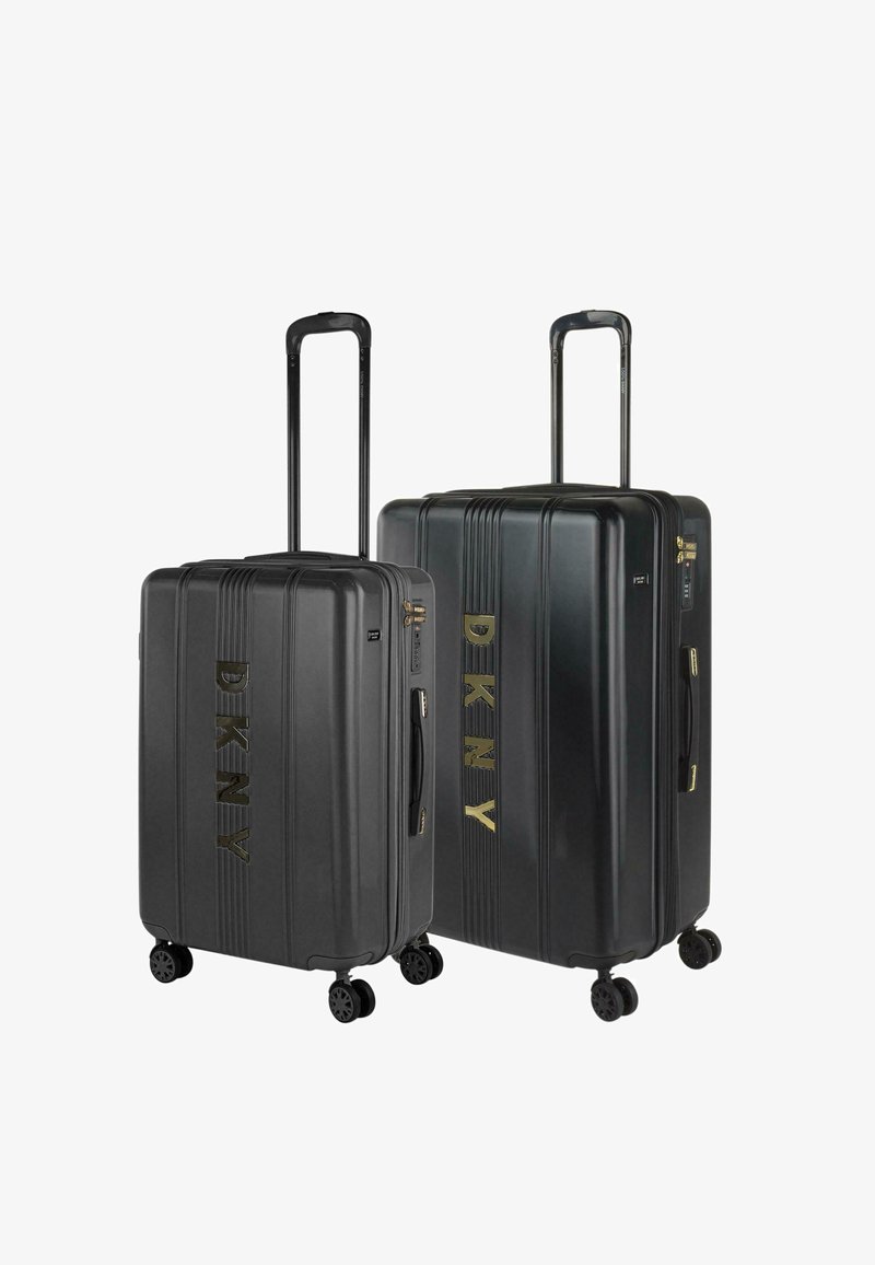Conjunto de maletas rígidas DKNY, color negro, con diseño de rayas verticales, logo dorado, asas retráctiles y cuatro ruedas para mayor movilidad.