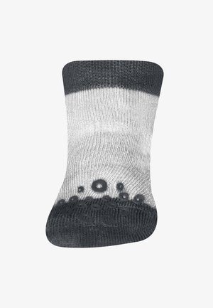 Calcetín a rayas gris y blanco con un patrón texturizado en la parte inferior, que cuenta con gomas de caucho negro que proporcionan mayor tracción.