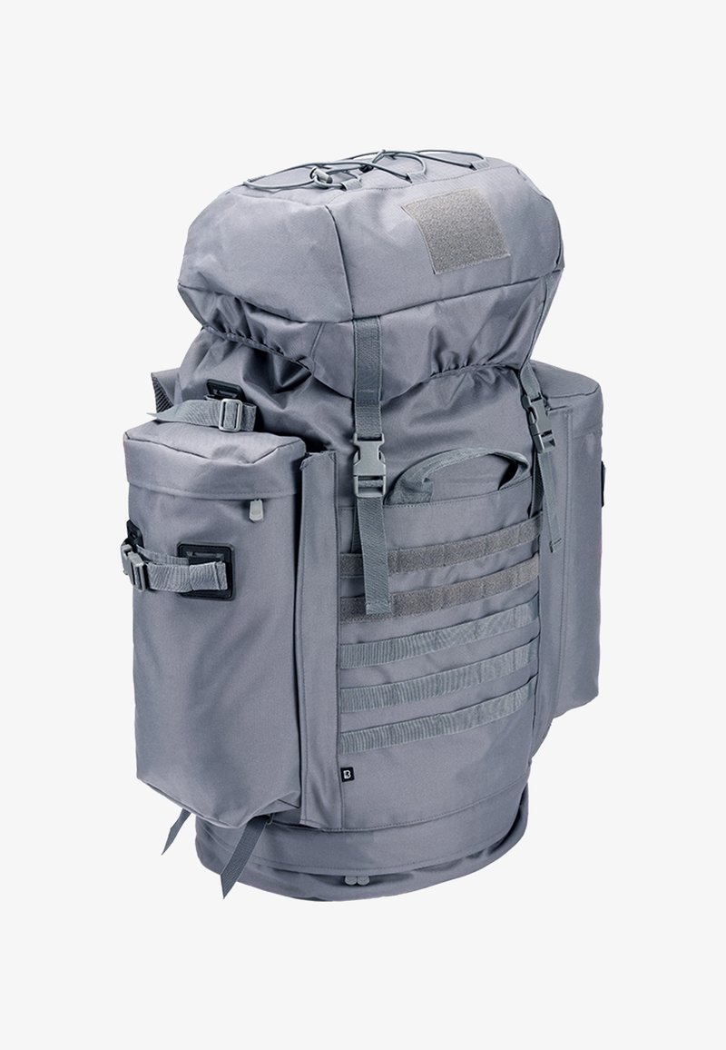 Grand sac à dos tactique gris avec plusieurs compartiments, sangles réglables et système MOLLE à l'avant et sur les côtés pour les accessoires.