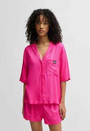Pink satin sleep set featuring a short-sleeve button-up shirt with a pocket and matching shorts, creating a smooth, relaxed silhouette.
