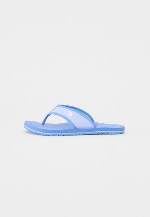 Niebieskie gumowe klapki z teksturowaną wkładką, pasami w dwóch kolorach i logo marki. Lekka konstrukcja, idealna do codziennego użytku.