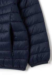 Marineblauwe donsjack met een doorgestikt ontwerp, gladde textuur, ritszak en ribgebreide manchetten. Kenmerkt zich door een lichtgewicht, gevoerd materiaal.