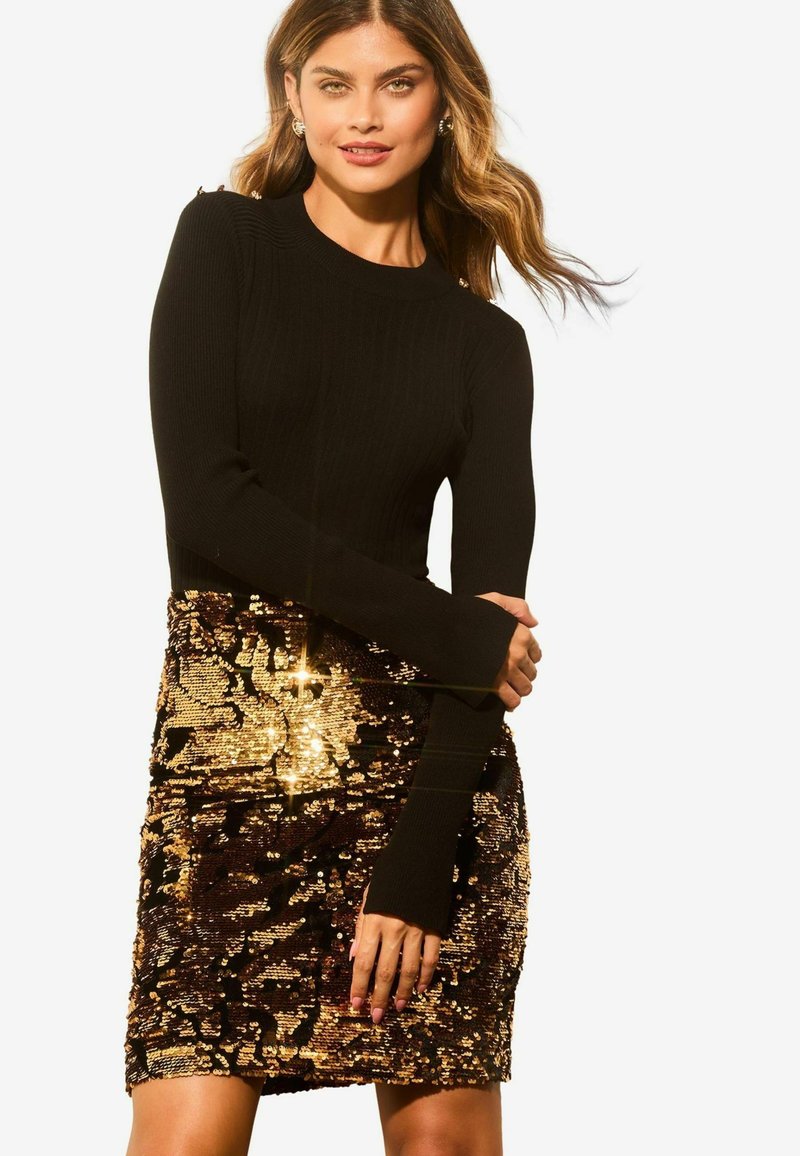 Zwarte geribbelde lange mouw top gecombineerd met een mini-jurk versierd met bronzen en gouden pailletten, met een getailleerd silhouet en een zachte textuur.