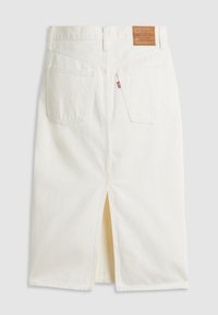 Jupe midi en denim blanc avec une fente au dos, deux poches arrière, des passants de ceinture et un patch de marque Levi's marron.