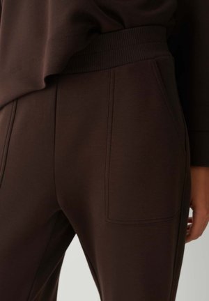 Braune Sporthose mit einem gerippten Bund und einer Seitentasche. Glatte Textur und lässiges Design, betont eine entspannte Passform.