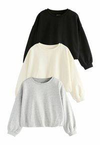Trzy bluzy crewneck w kolorach czarnym, kremowym i szarym. Każda z nich ma długie rękawy, ściągacze i luźny krój. Miękka faktura materiału.