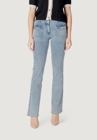 Jeans in denim blu chiaro con taglio dritto, presentano due tasche frontali con chiusura a bottone e una leggera texture sbiadita.