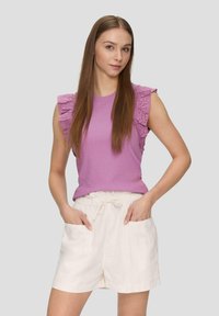 Lila mouwloze top met ruches van oogjes, gecombineerd met lichtbeige short met een elastische tailleband en zijzakken.
