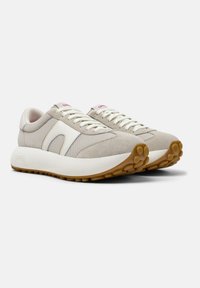 Sneaker beige caratterizzate da una combinazione di rete e suede, con un accento in pelle bianca, lacci tono su tono e una suola in gomma testurizzata.
