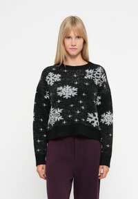 Schwarzer gestrickter Pullover mit Schneeflockenmuster in Weiß und Silber. Verfügt über einen Rundhalsausschnitt und gerippte Bündchen, mit einem kurzen Design.