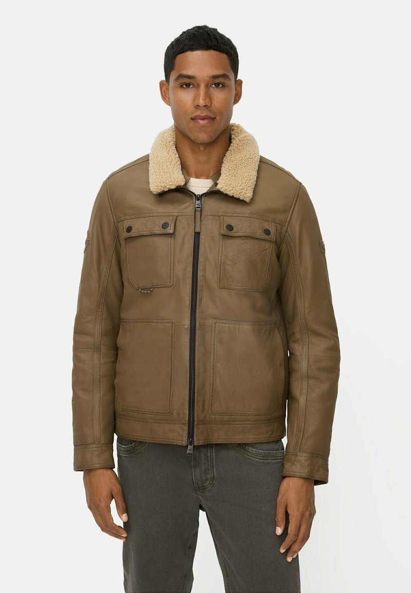Braune Lederjacke mit einem cremefarbenen Schaffellkragen, ausgestattet mit zwei Brusttaschen, einem Reißverschluss vorne und glatter Textur.